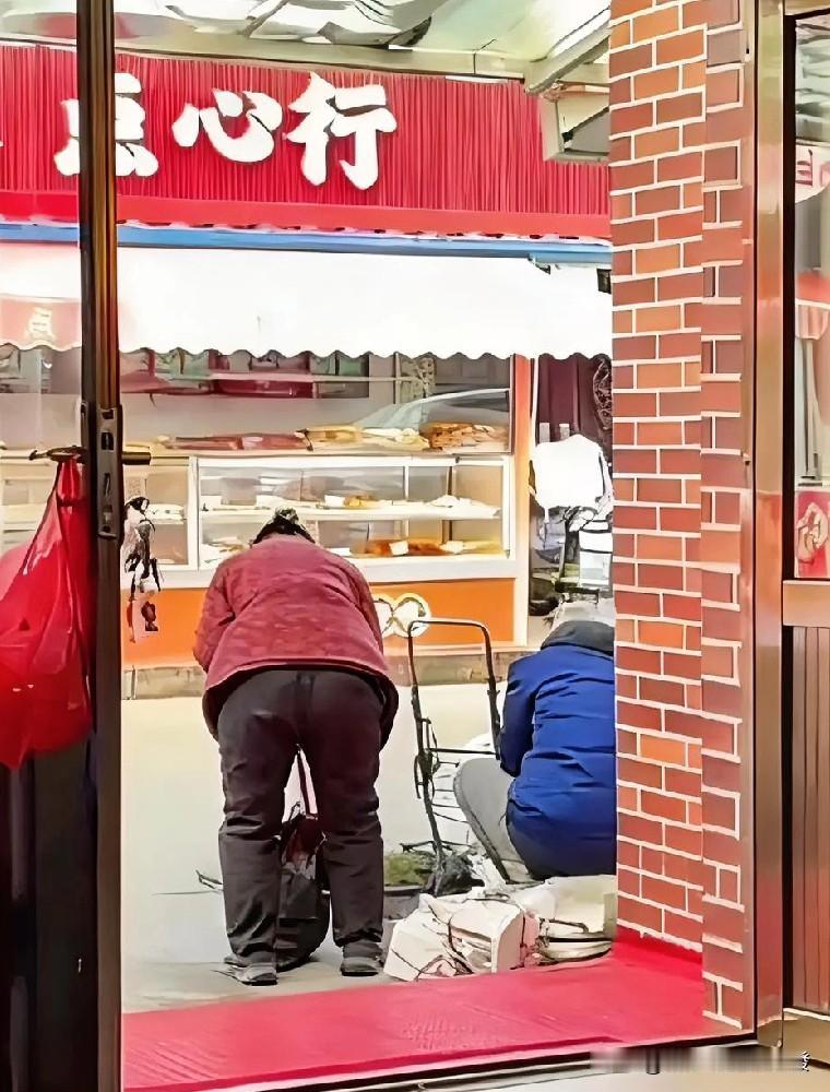 1对老两口用手推车拉了一点花生和地瓜，停在一家店铺正门口后，就把摊子铺开叫卖起来