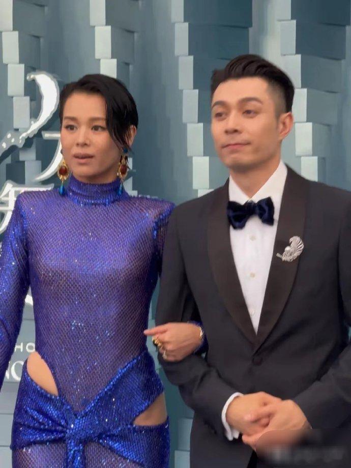 胡杏儿着蓝色透视裙，与周柏豪挽手亮相红毯，造型吸睛，尽显优雅气质，二人同框画面引