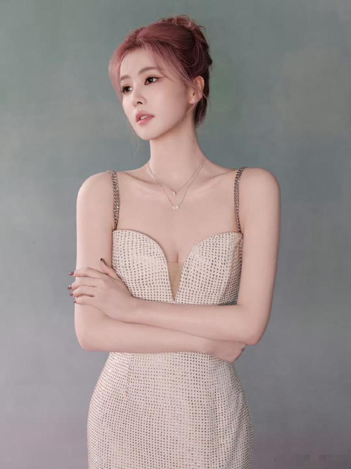 白鹿尝试粉色盘发，发色浅粉柔和，盘发设计精致，她轻吻花朵的姿态让整体形象更添灵动