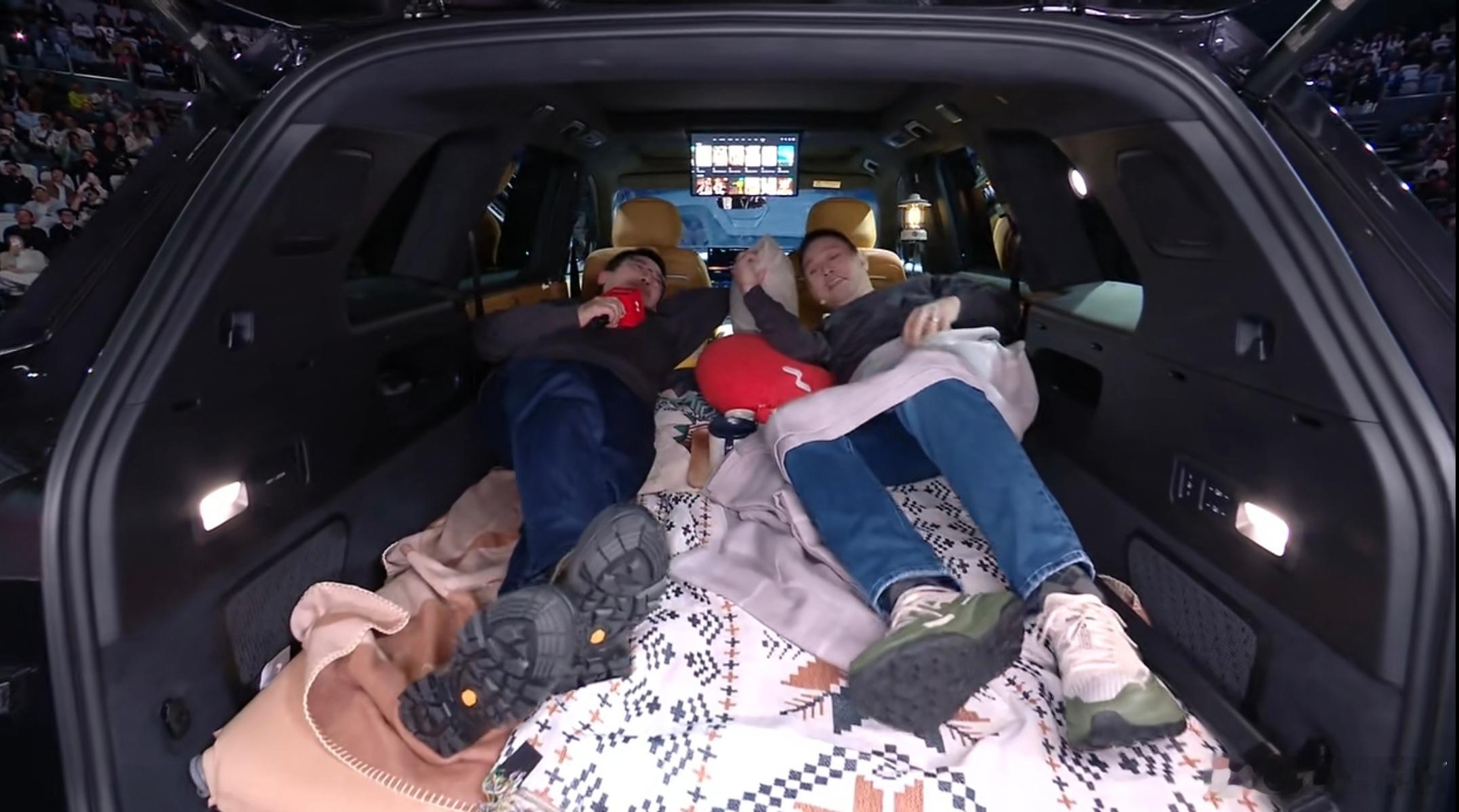 好了。这是汽车发布会历史上，第一对现场直播睡车里的老板组合。李斌+秦力洪，一边躺