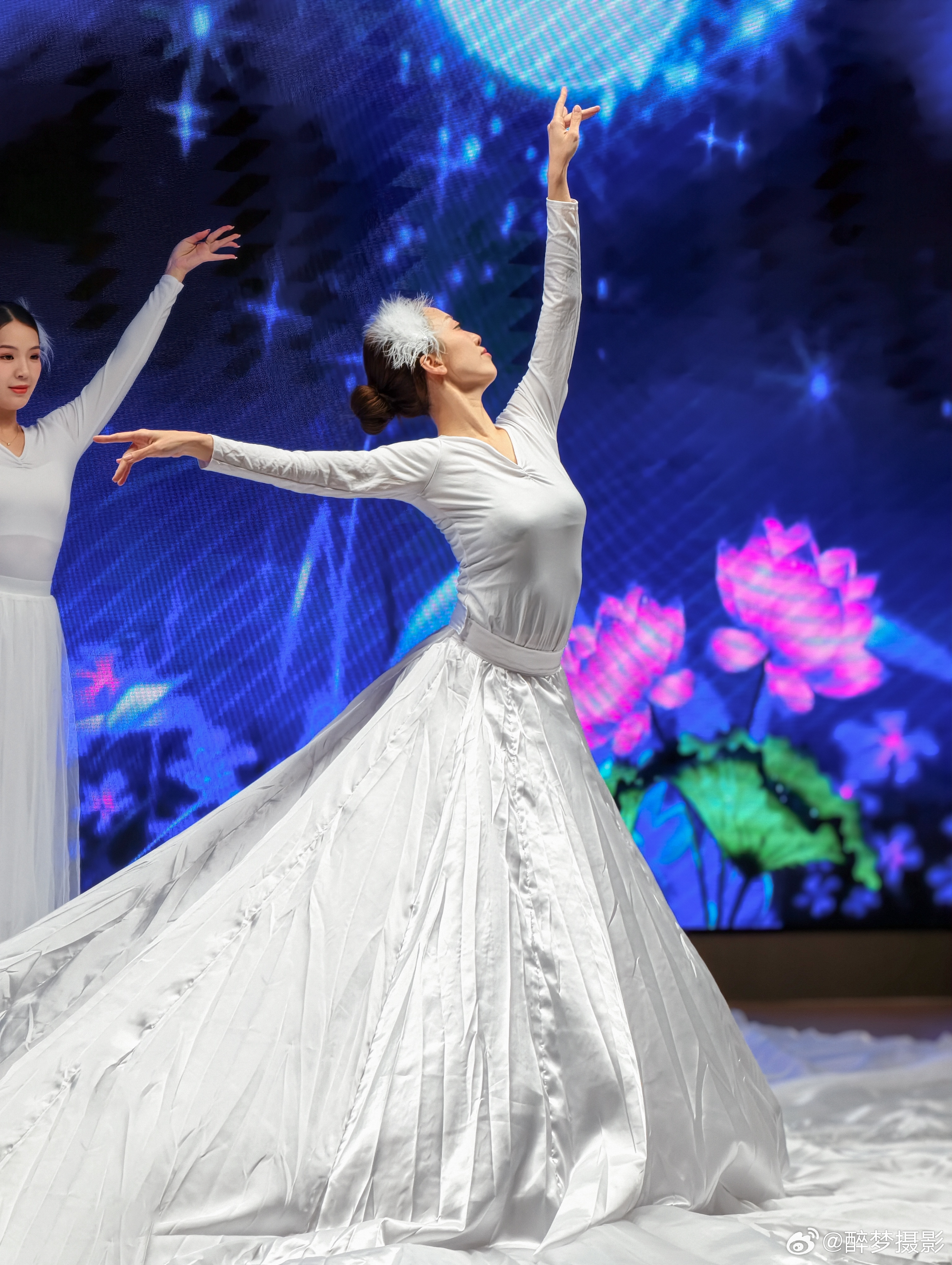 🌊《海洋精灵》舞动时刻  白衣翩跹如浪花，发间羽饰似海风轻拂。在梦幻蓝屏与莲花