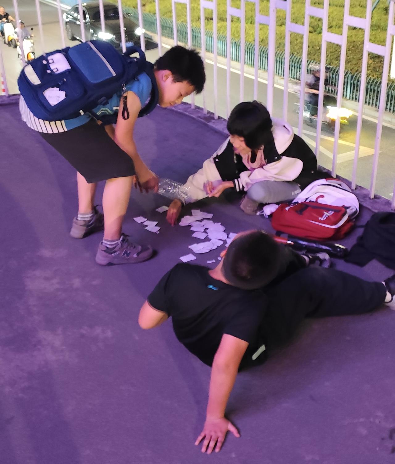 瞧瞧，街边一角这小女孩跟两个男孩玩卡纸赌博大获全胜,把两个男孩手里的赢了个精光，