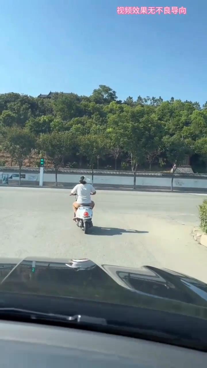 女子坐电车上挠痒痒时被后面车子催促，下一秒她吓得骑车走忘了穿鞋子。
红绿灯处女子
