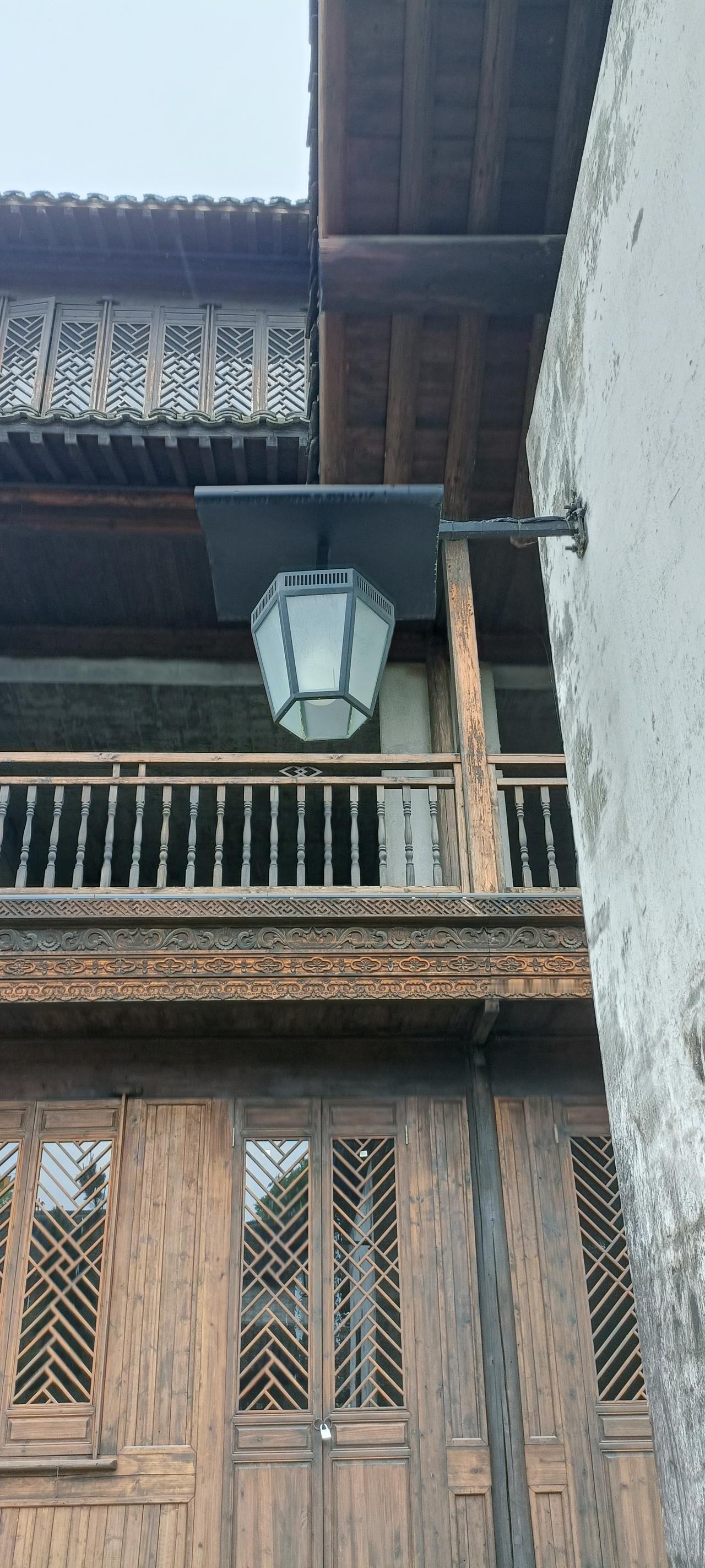 古朴的木制阳台，散发着历史的韵味。
上联:木楼灯影映，
下联:古韵入画来。