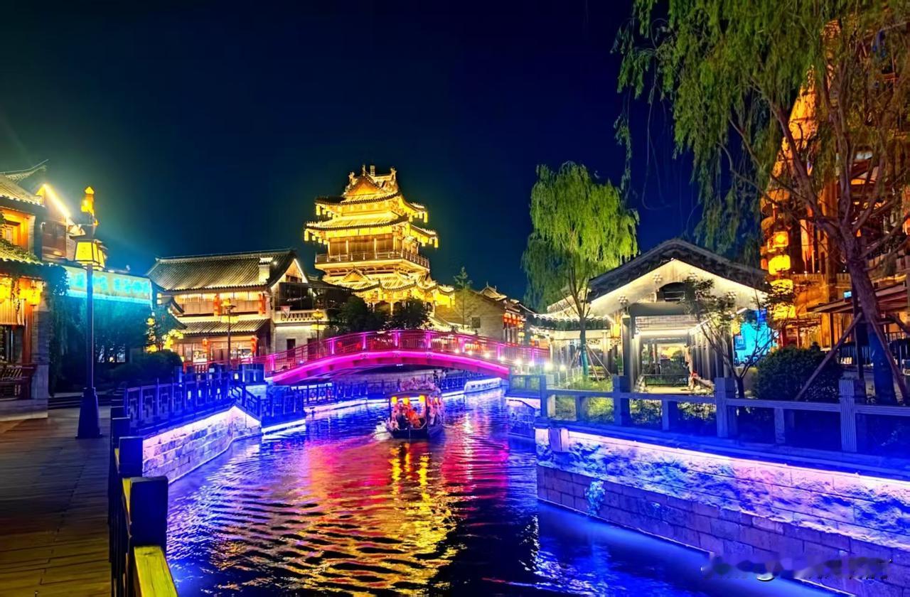 夜幕降临，山东临沂琅琊古城灯火辉煌，万千灯光勾勒出古朴楼宇的轮廓，小桥横跨潺潺流