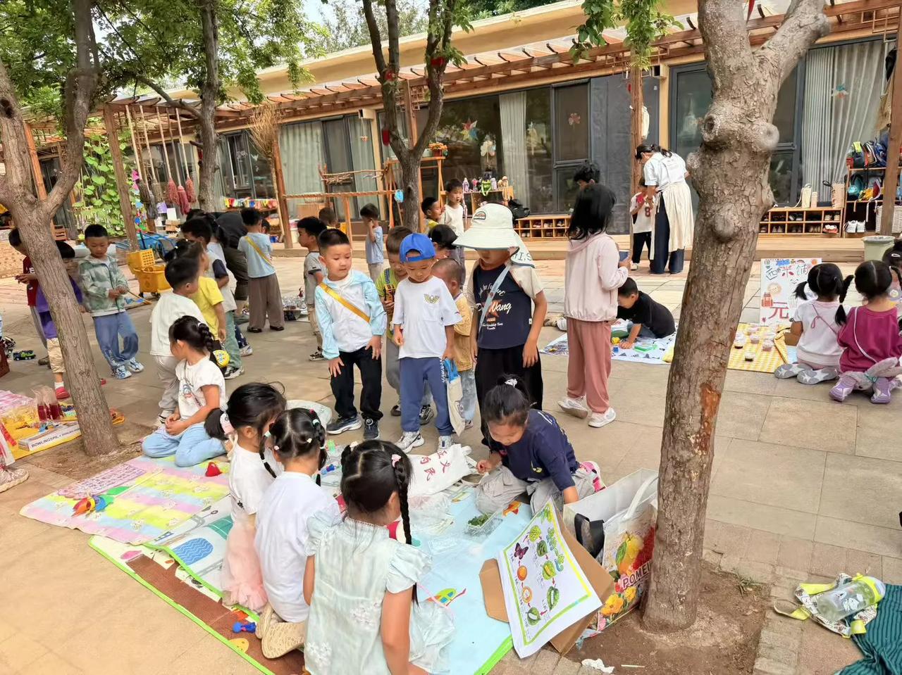 幼儿园的跳蚤市场热闹非凡，孩子们变身小小摊主。小桌子上摆满绘本、玩偶、积木，稚嫩