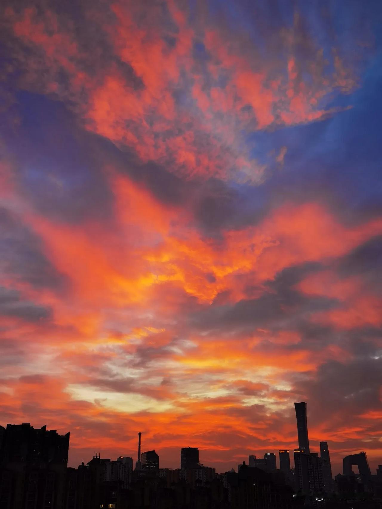 分享今日美好——京城喜见火烧云！
晴空一日晚升云
悄悄遮掩夕阳身
岂甘平平隐山外