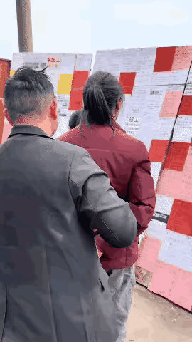 粘蝇纸还可以这样用？痛快！
几个人在看招工信息，穿红色羽绒服的男人在前，穿黑色皮