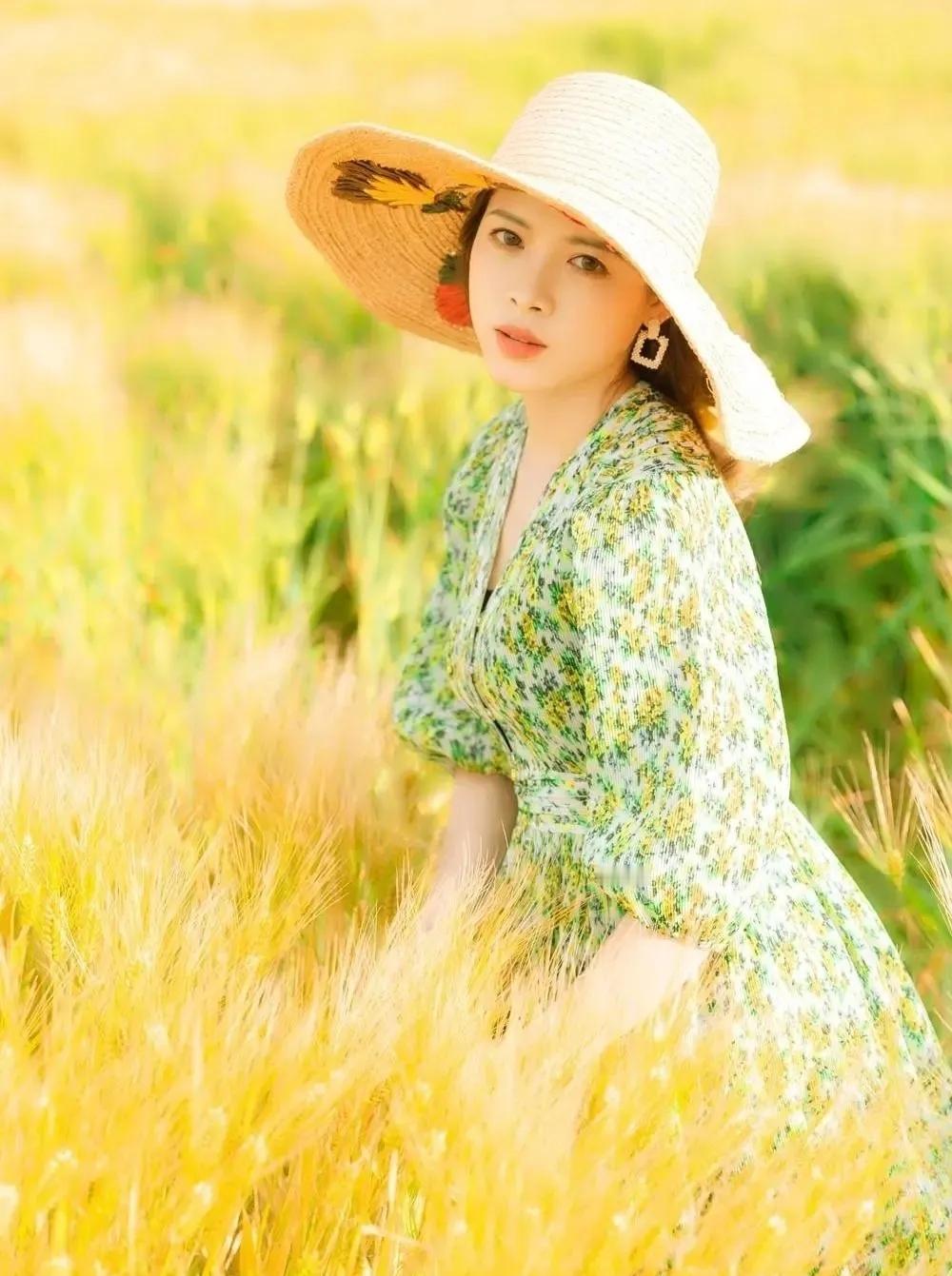 想象一下，在那片金黄的麦田里，一位戴着草帽的姑娘在微笑。她身着绿色连衣裙，与金黄
