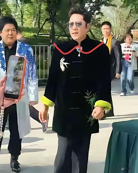 蔡国庆这身穿着打扮，不走常人路线。黑色的衣服，大众路线，无可厚非。那绿袖子，身上