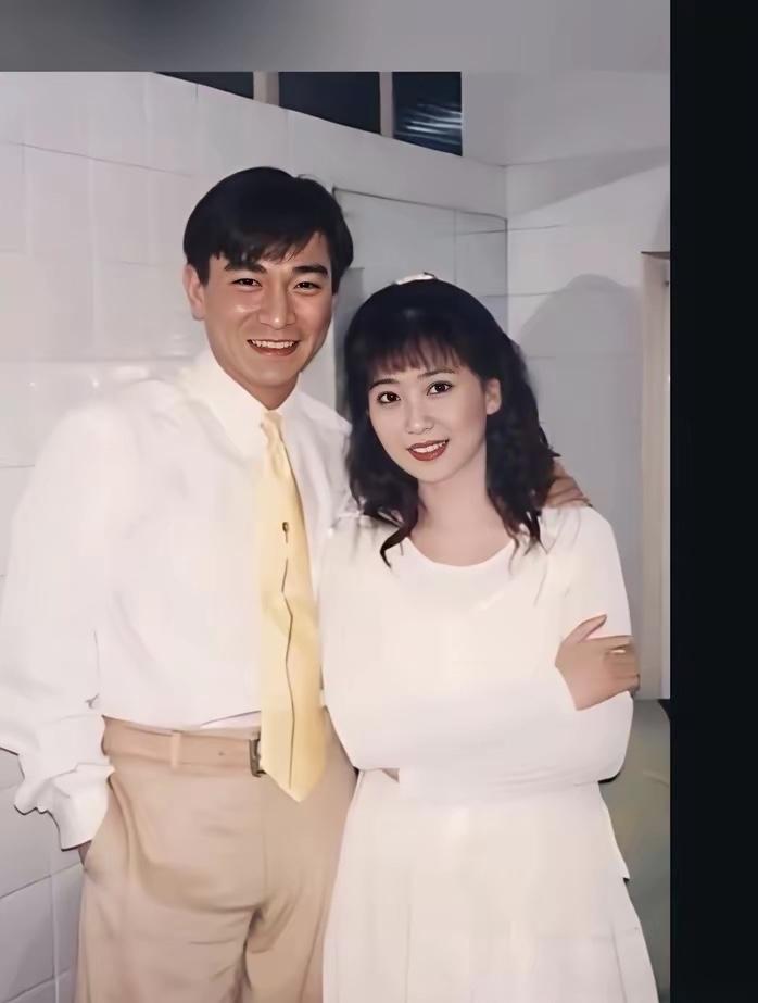 穿着白色衬衣，打着领带的这位是大明星刘德华，他年轻的时候还蛮帅的，头发乌黑发亮，