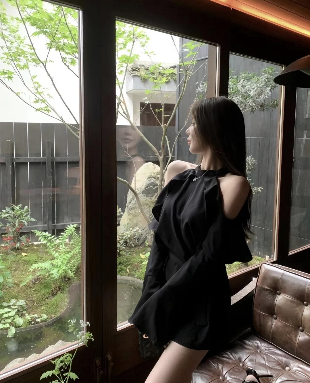 窗边偷得半刻闲，把庭院的青意揉进衣角的褶皱里。黑裙与绿意撞个满怀，连风都带着点松