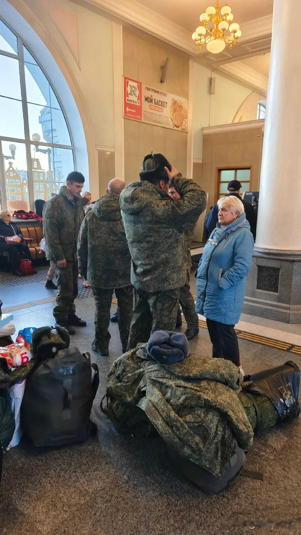 俄罗斯莫斯科，一位老母亲正在车站里送别即将奔赴战场的儿子。
她看着年轻的儿子，眼