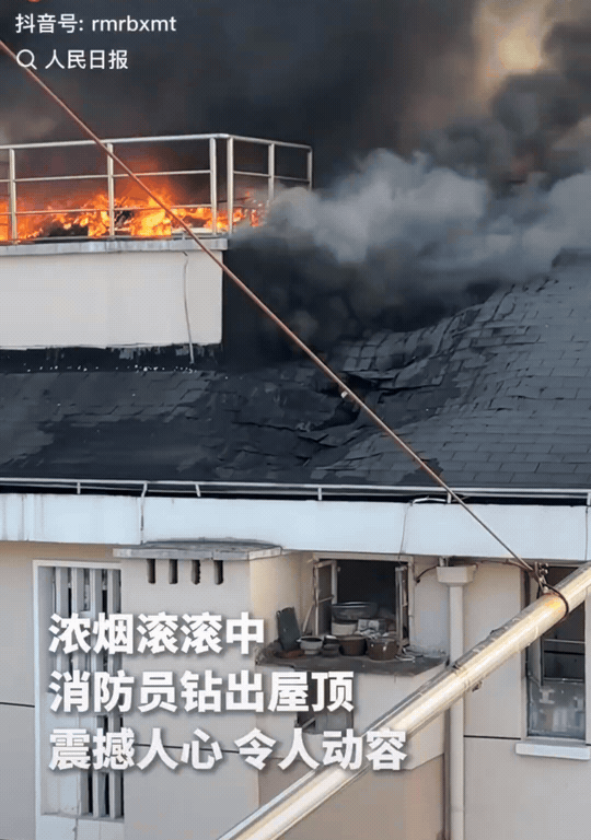 看感动了！上海，居民楼屋顶大火，火势很大，浓烟滚滚。在烧得漆黑一片的屋顶上，突然