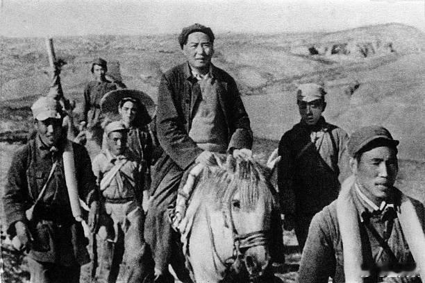 1947年摄于马背梁峁。毛主席骑白马，牵马者为王振海。毛主席左右是两名警卫员，石