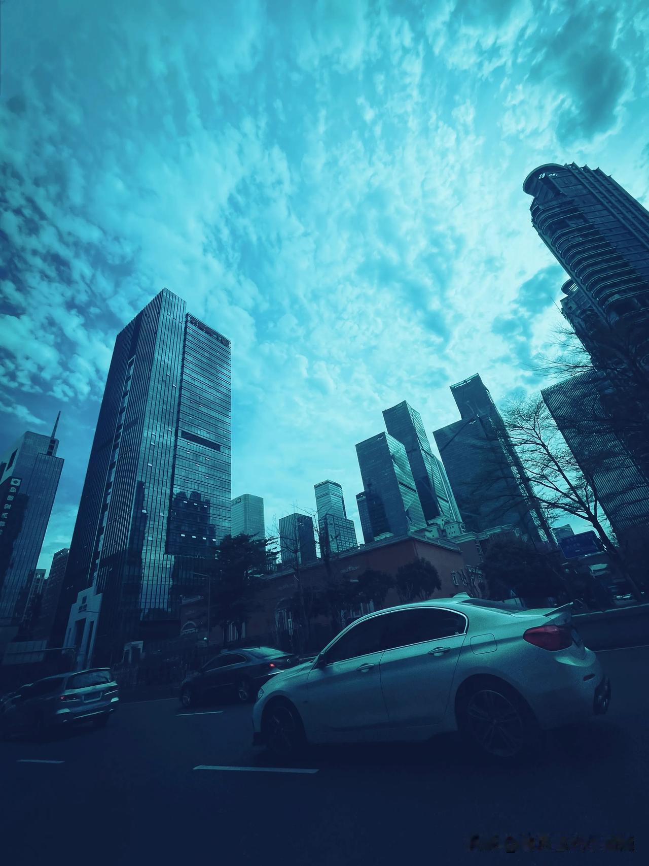 城市高楼耸立，车流穿梭，蓝天白云映衬下更显壮观。