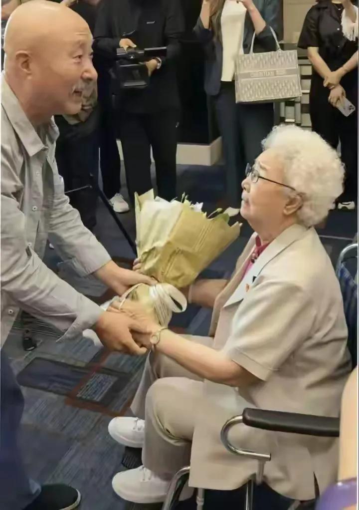 陈佩斯给97岁的田华献花，这画面里藏着三代人的故事呢。当年田华一句话，陈佩斯和朱