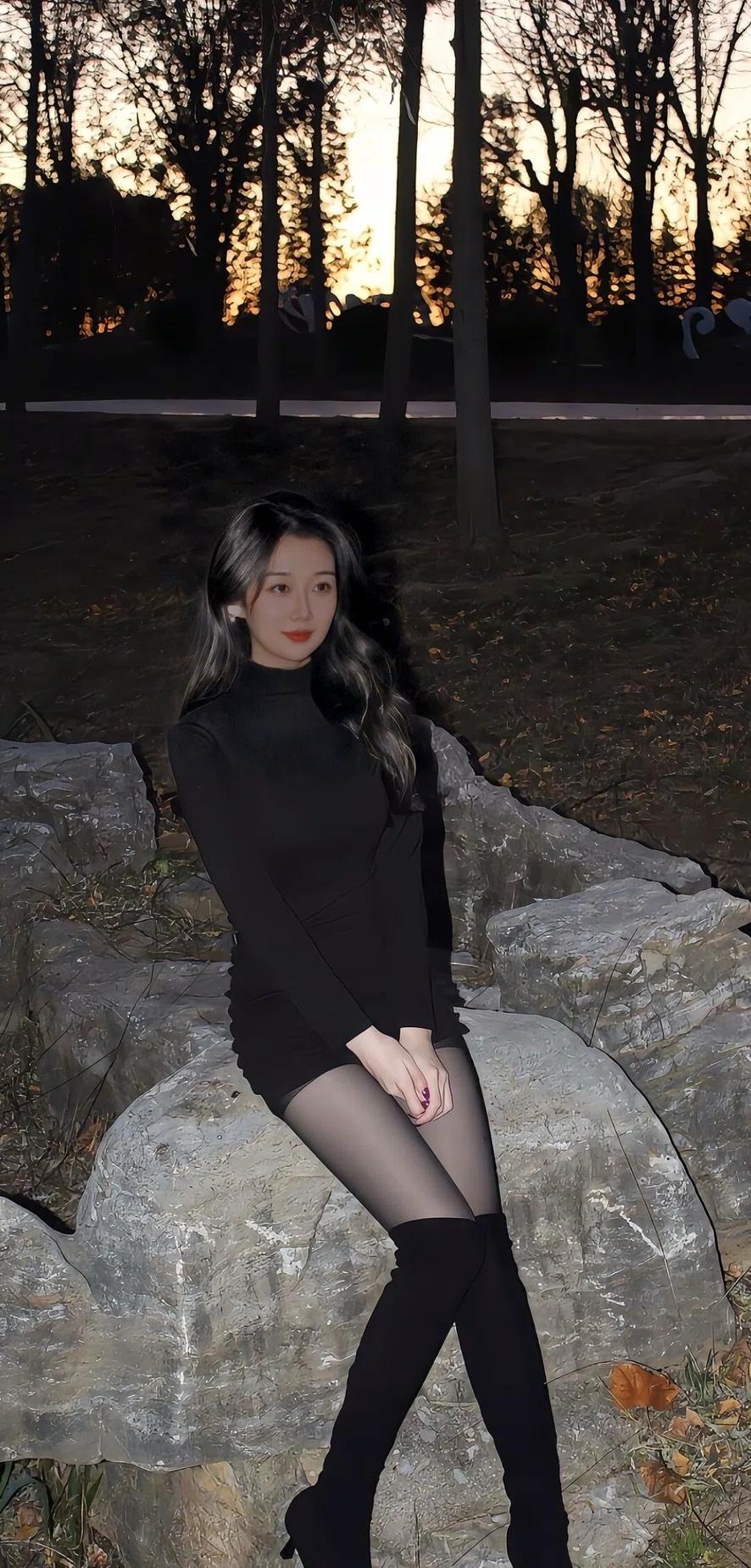 秋日黄昏，黑裙少女倚石而坐，静享落日余晖。