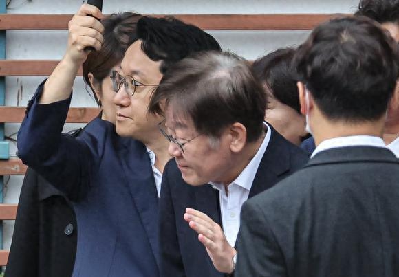 李在明这张照片，他后面那男子被拍得有点不自然，画面不是很和谐。