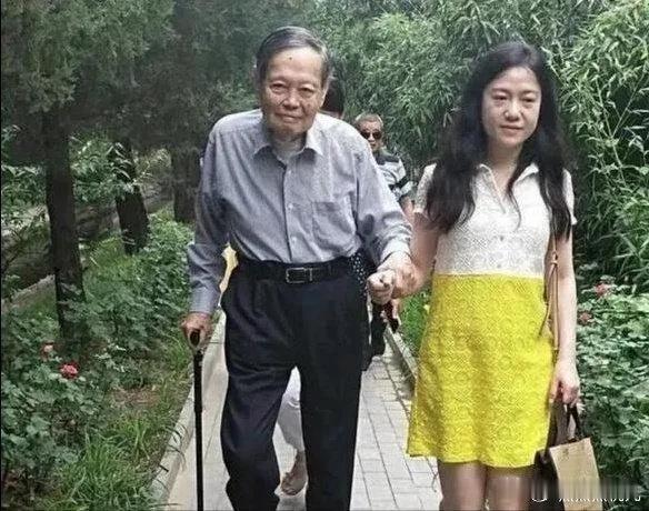 102岁的杨振宁和翁帆外出，杨老步履蹒跚，拄着拐杖，满头银发，看起来有些吃力，妻