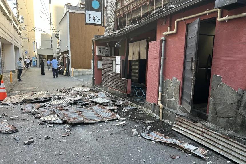 如图所示，位于熊本县震中区域的一家商店的广告牌，坠落在地上，坠落的广告牌锈迹斑斑