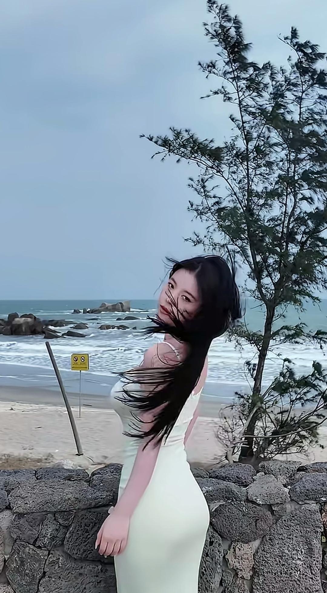 海边风景美，她穿着长裙在拍照。