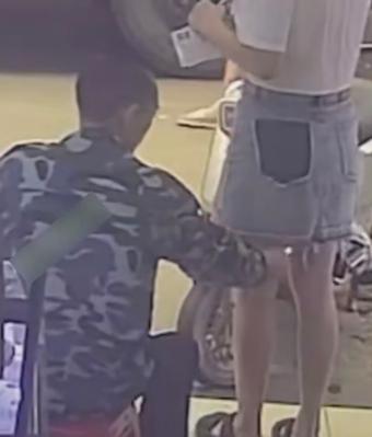 手怎么那么欠!一名男子趁一名女子站在路边低头看手机毫无防备时，悄悄蹲到她的身后，