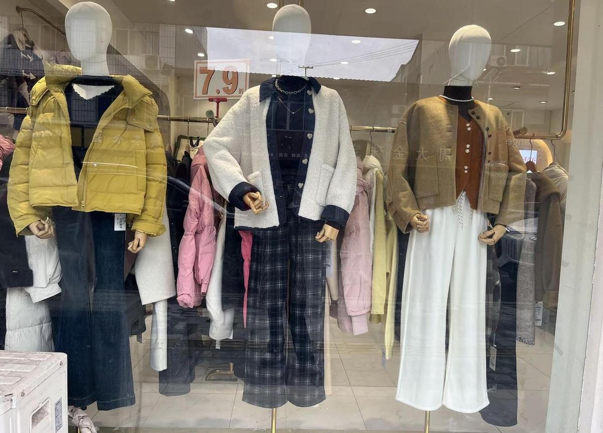 在街角的服装店，老板娘一边整理衣架，一边给顾客讲“这件外套配这条围巾，气质立马不