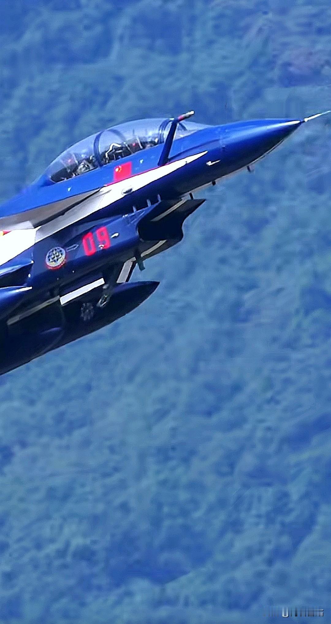 大坡度爬升的歼 - 10S表演机上，后座舱的飞行员被左边山上的某物吸引了注意力，