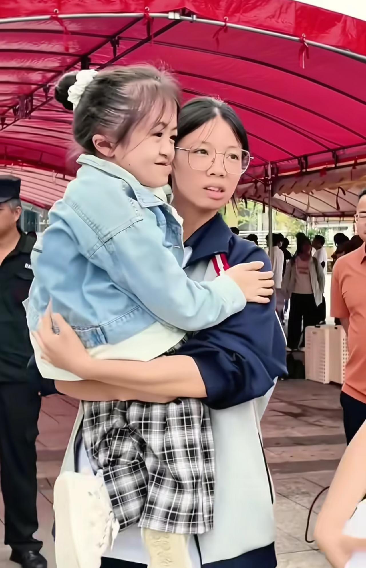 考场外温柔一抱，不知道的还以为是妈妈抱起了孩子，其实是同学抱起了同学，这一幕感动