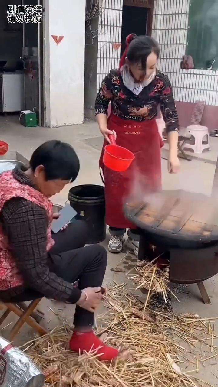 婆婆烧火时只顾着看手机，下一秒她的鞋子放灶火里都不知道。
婆婆正在烧火做饭，这时