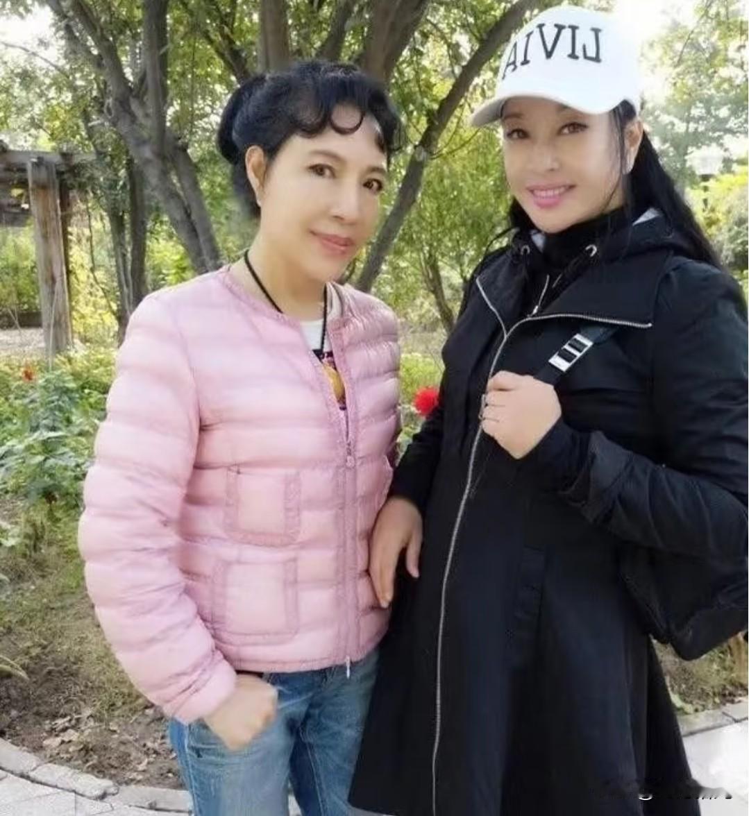 这张合影当中的两个人，我们一眼就能看出，头戴白色鸭舌帽、身穿黑色外套的是刘晓庆。