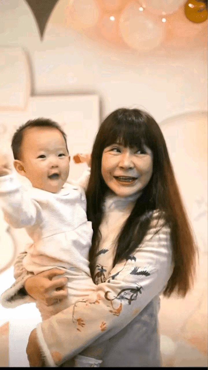视频中是黄一鸣的母亲抱着外孙王闪闪的情景，孩子手舞足蹈，真可爱，外婆笑的更是幸福