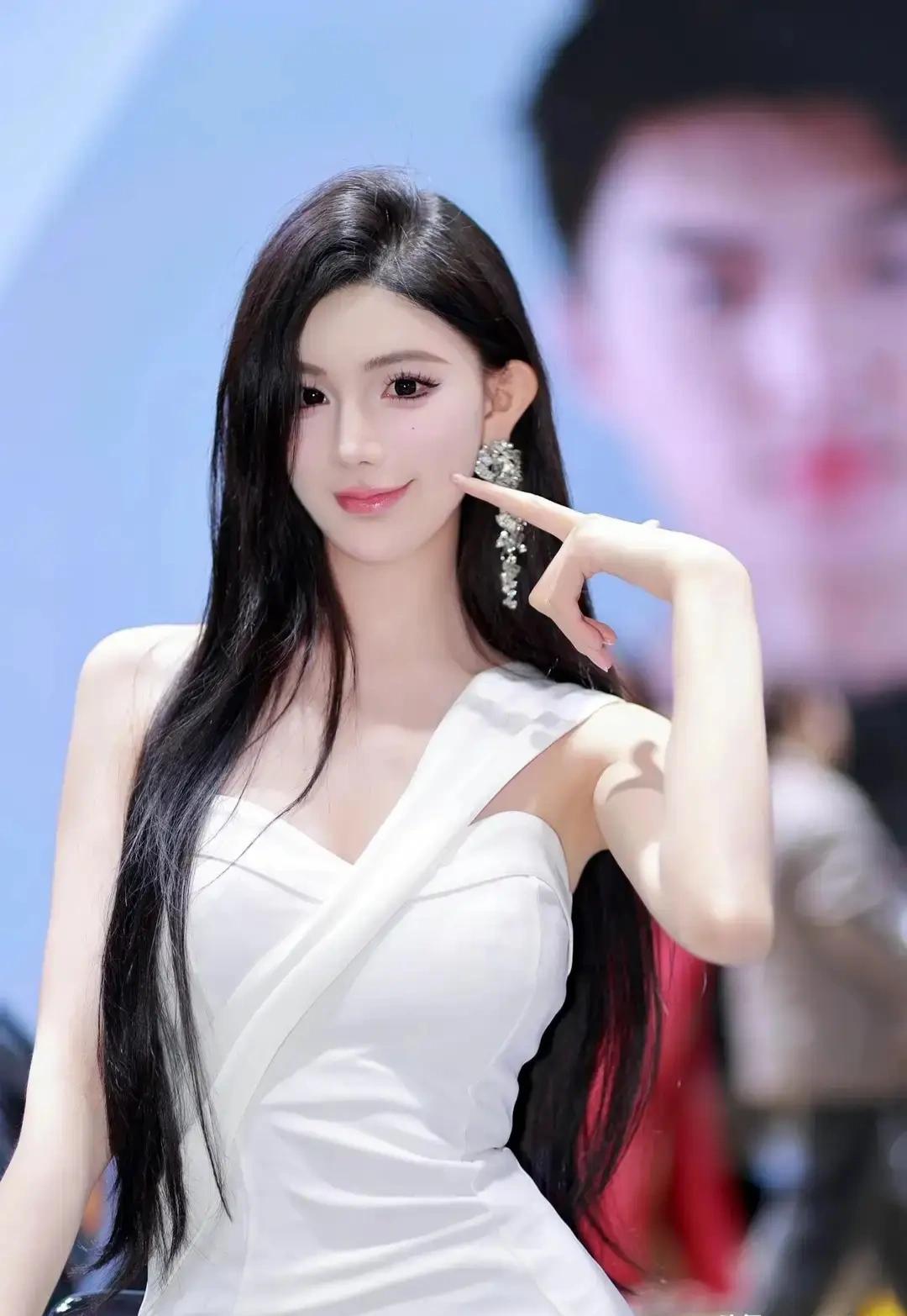 《车展上的白色优雅》
在光线交织的车展大厅里，一位模特站在一辆闪亮的汽车旁，如同