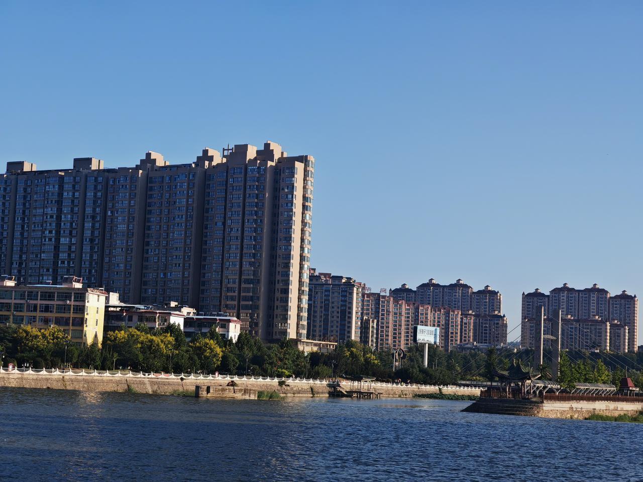 美丽风景共欣赏澄澈蓝天之下，河水静静流淌，波光轻轻荡漾。河畔高楼林立，楼宇错落排