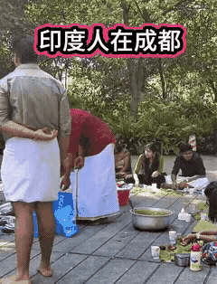 印度人在中国成都公园里开party，在公园的栈道上一字摆开坐好，把他们最喜欢吃的