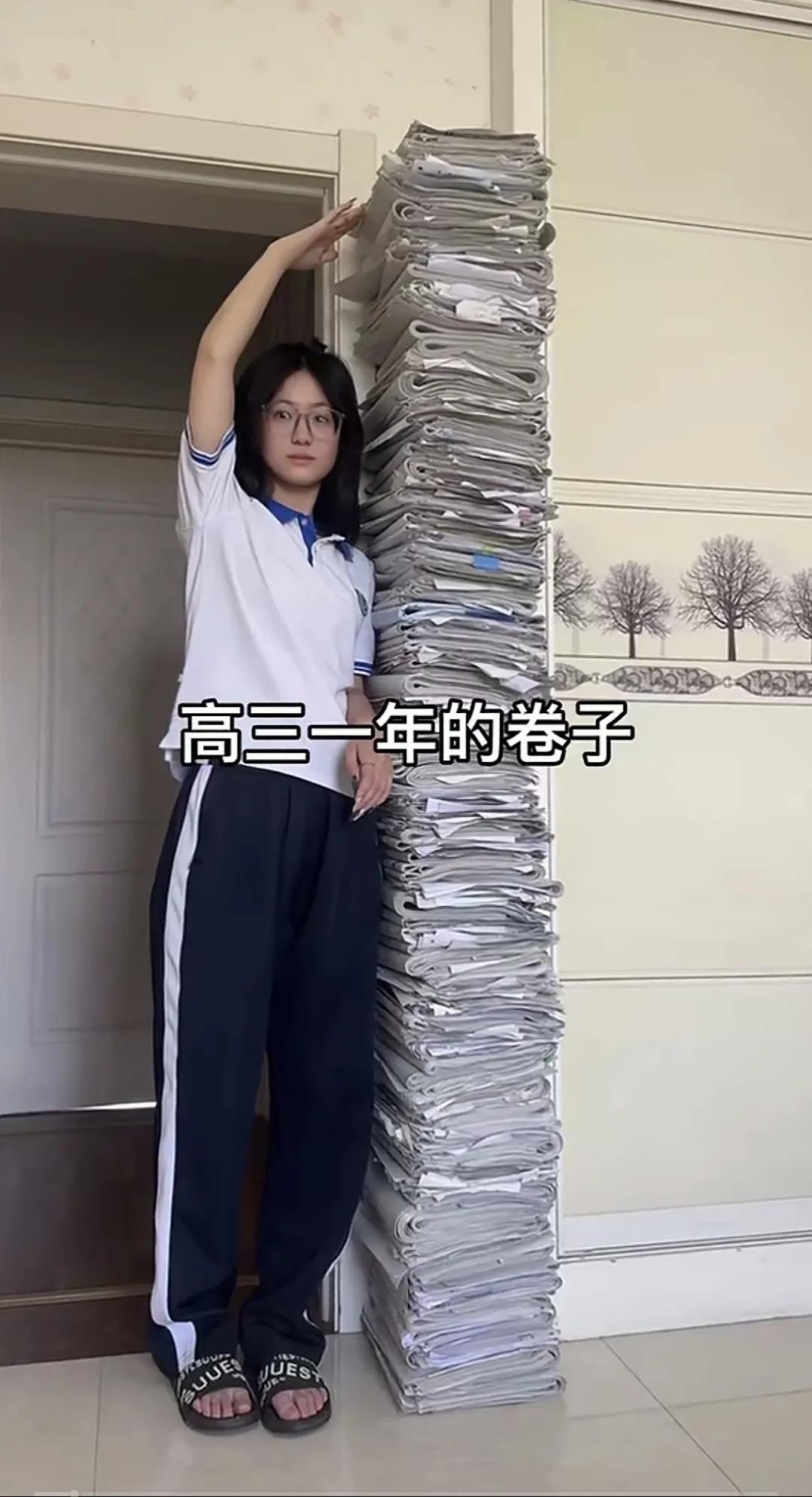 一张试卷0.1㎜，目测两米高，那就是两万张试卷，但视频里的应该是折起来的试卷，有