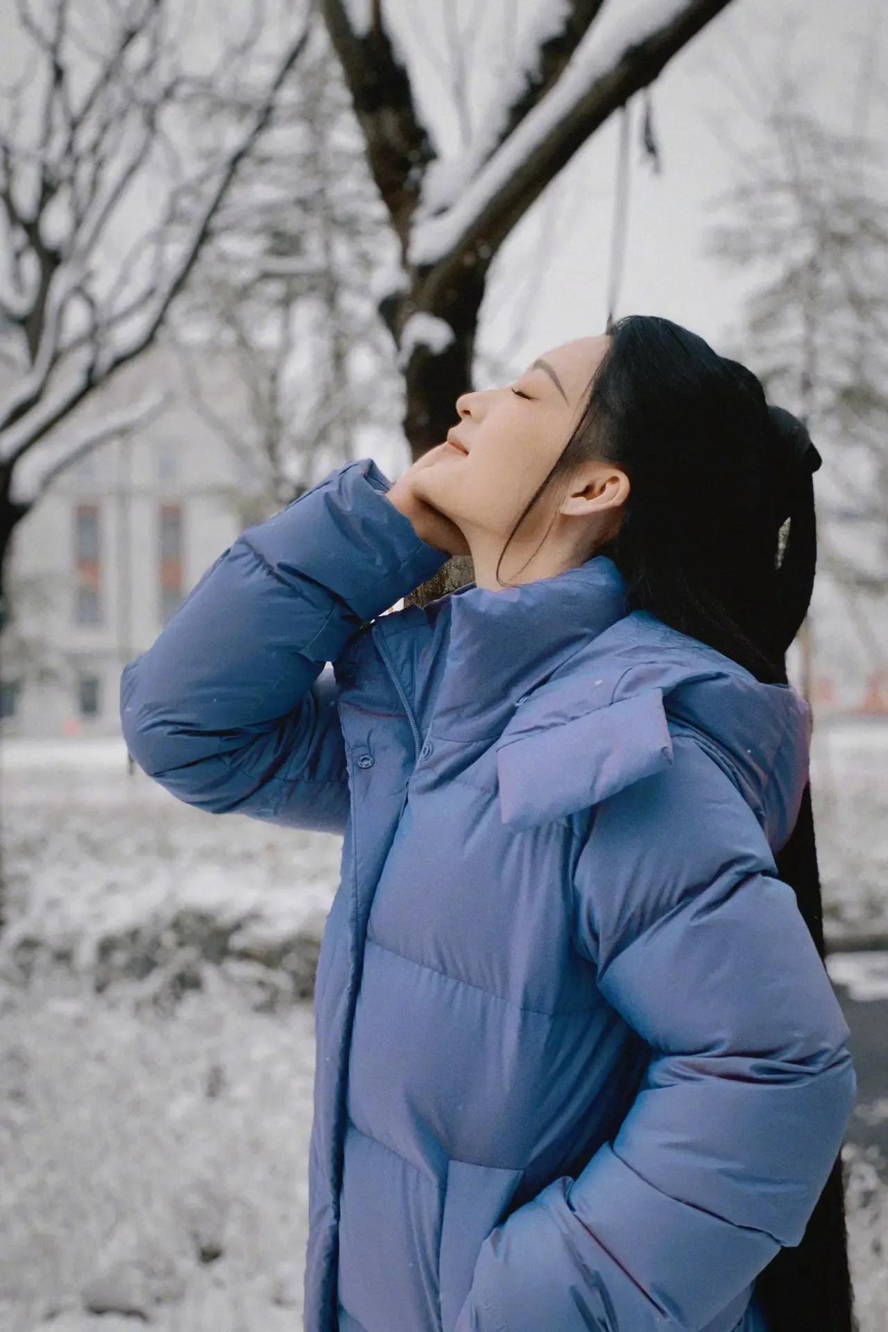 李沁雪地摆拍造型真是太美了，穿蓝色羽绒服显得格外清新，乌海的头发扎着半马尾显得十