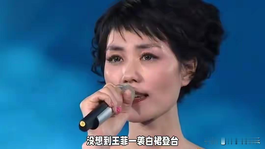 当王菲身着一袭纯净如雪的白色羊毛质地长裙，优雅地伫立在春晚舞台上那片暖黄色星光的