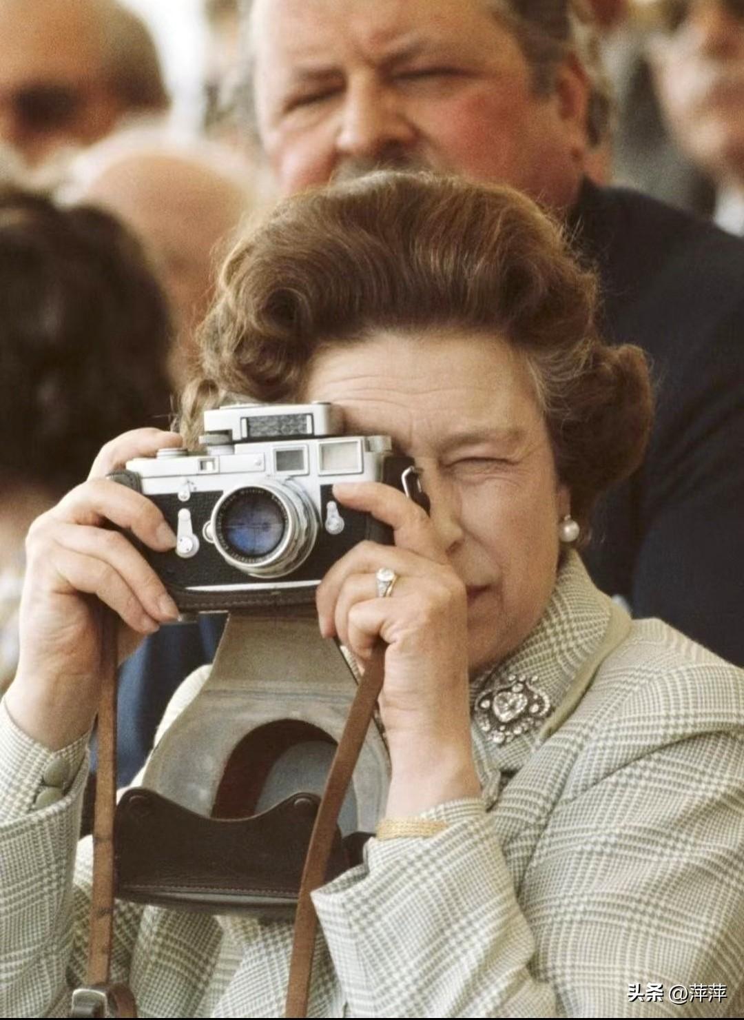 英国女王伊丽莎白二世，正举着莱卡相机专注拍摄。摄影是她一生的爱好，从年轻时就用镜