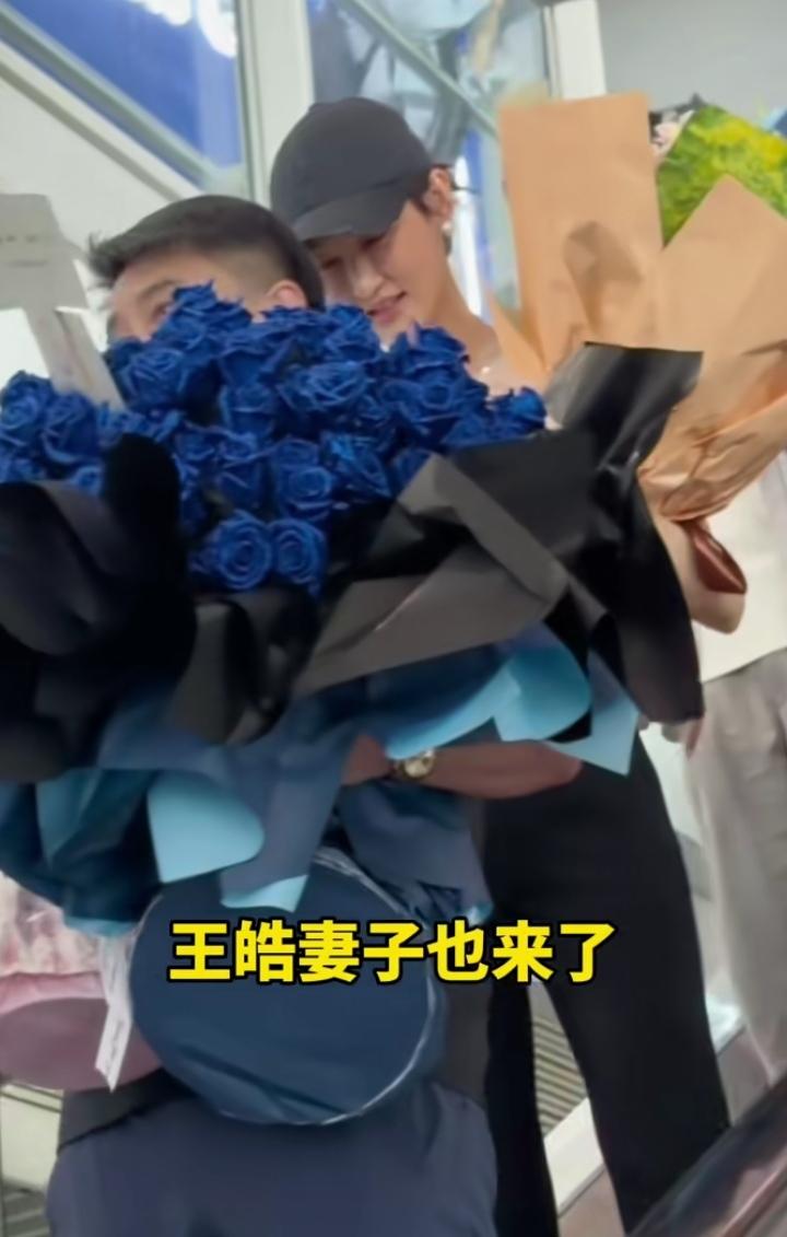 国乒大部队载誉回京啦，接机现场暖意满满，王皓一现身就成了欢乐焦点！手捧鲜花的他全