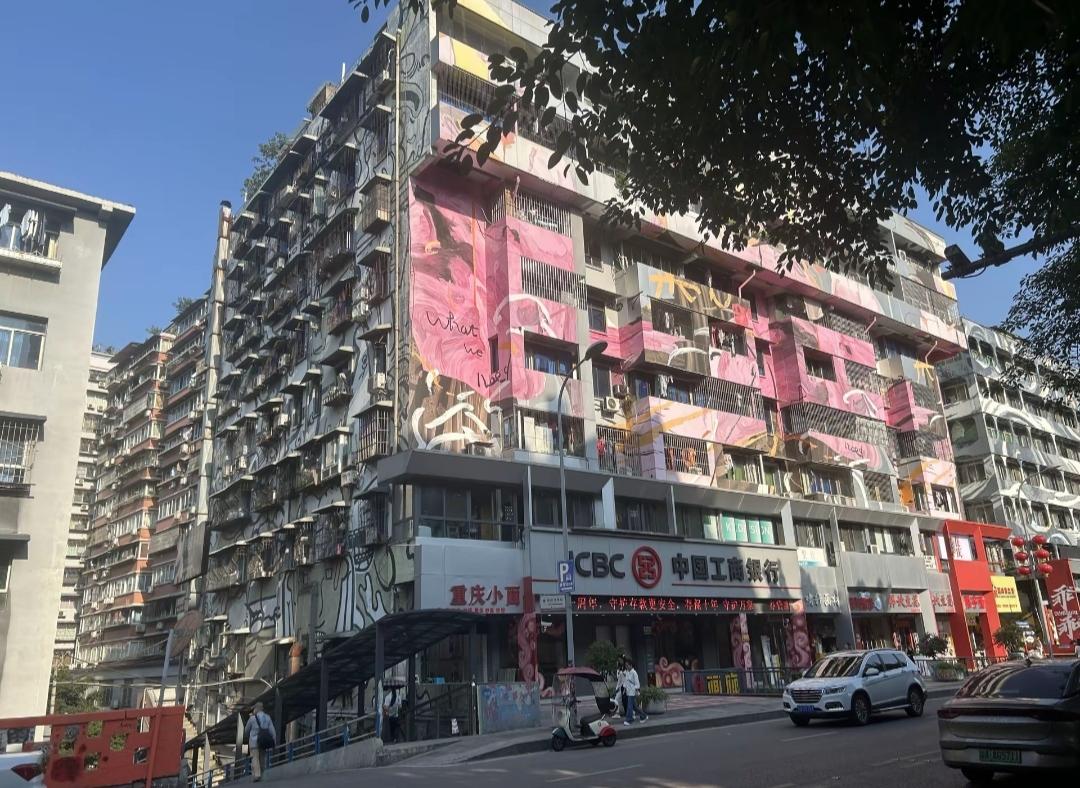街边有涂鸦的旧楼，楼下是银行和商店。景色真的挺美丽的。有机会一定要去欣赏一下重庆
