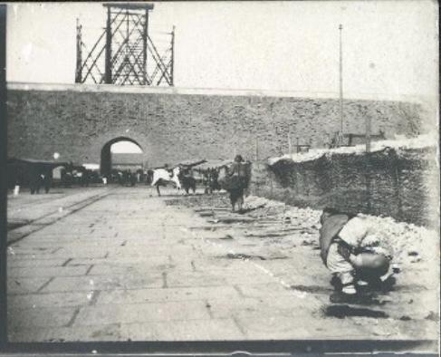 晚清（1901-1902年），北京，在御道边拉屎的男子。