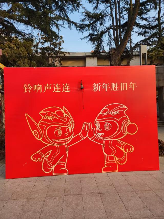 中车四方大门里在一个板面上，按了一个铃铛🔔，上面写着：“铃声连连，新年胜旧新”
