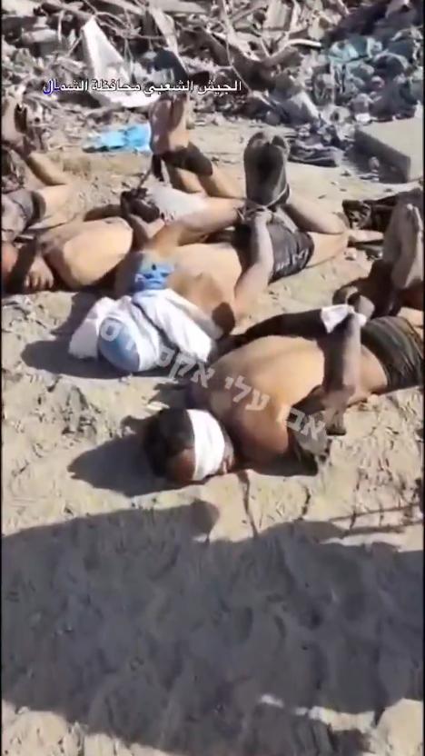 画面显示几名被捆绑并蒙住双眼的男子躺在加沙北部的沙地上；支持以色列的MOSSAD