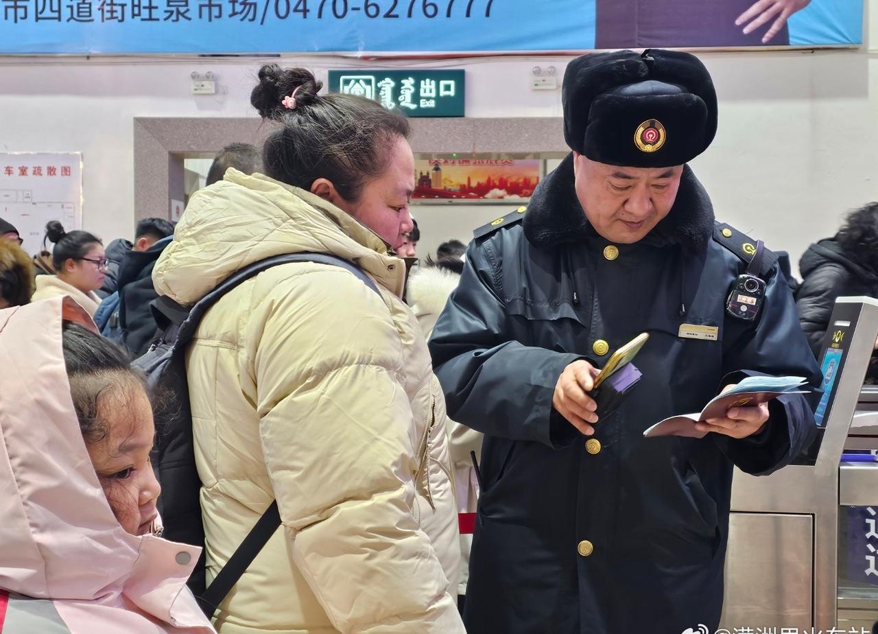 满洲里火车站检票口，工作人员仔细核对旅客证件与车票，耐心解答出行疑问。带着孩子的