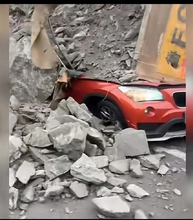 红色小车被渣土车，还是侧翻的碎石压扁了，轮胎都扁了。地上还流了一滩液体。
红色车