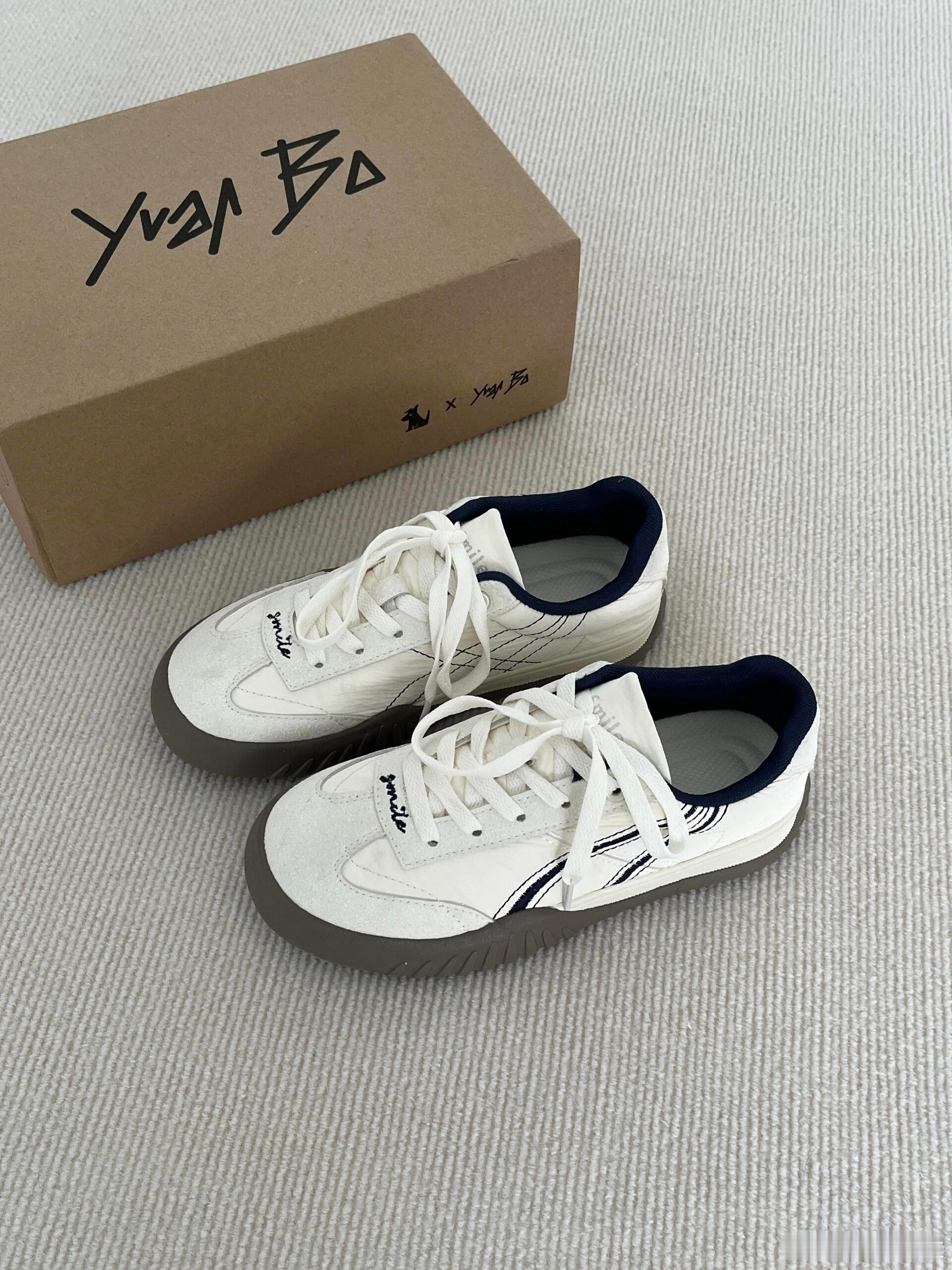 这双联名款休闲板鞋，搭配印有“Yue Bo”手写体及合作标识的棕色鞋盒，整体呈现