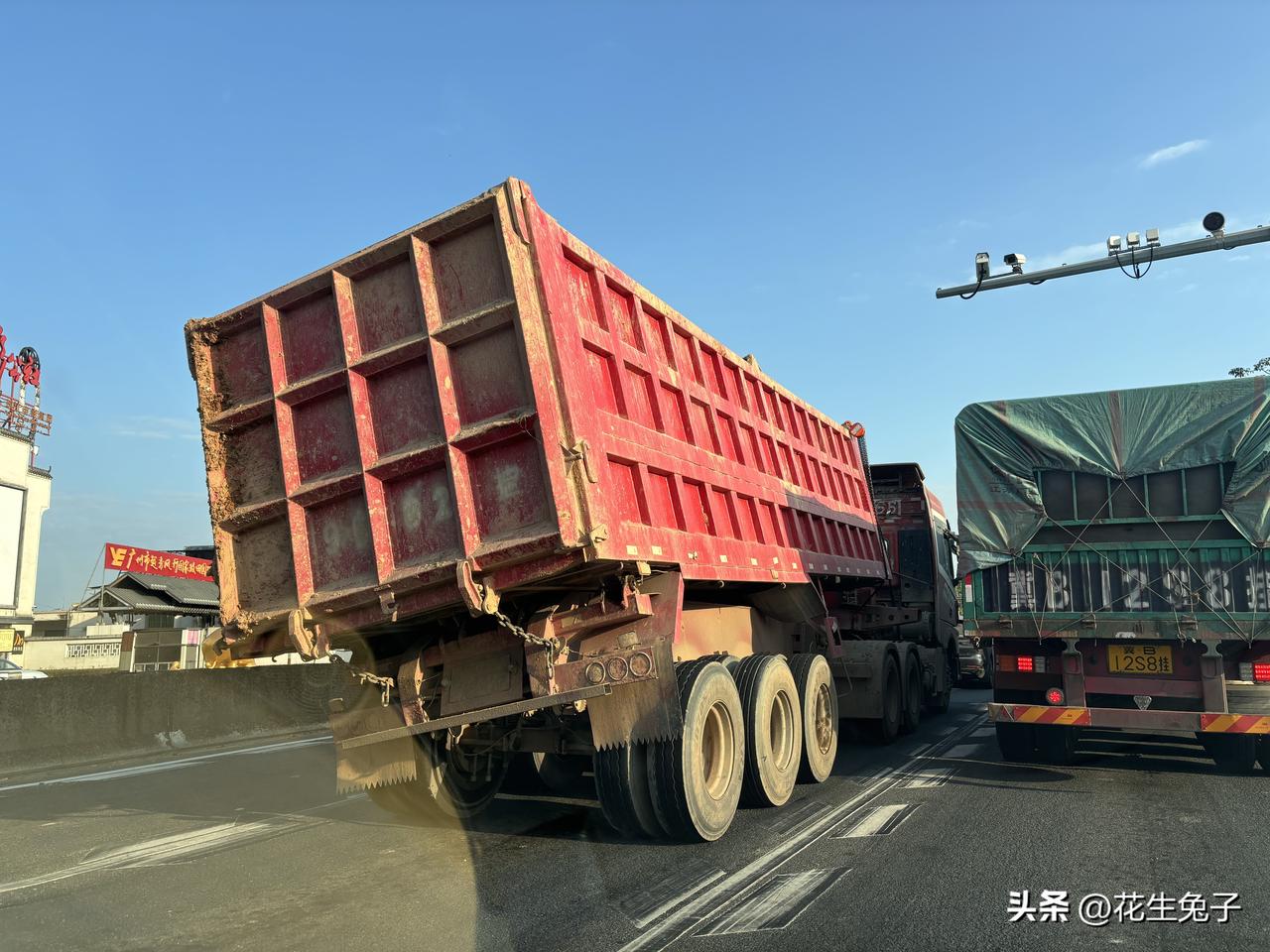 倾斜的大货车，看上去摇摇欲坠，如果货舱这样倾倒了压倒正常行驶的过往车辆，大货车要
