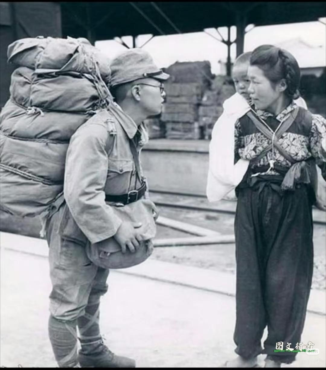 1941年，日本，一位日军新兵正在车站与妻儿告别，他戴着眼镜，背着厚厚的行囊，身